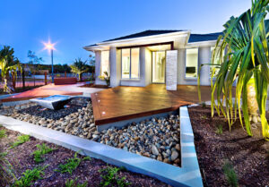 Garden of a house beautifully illuminated at dusk.