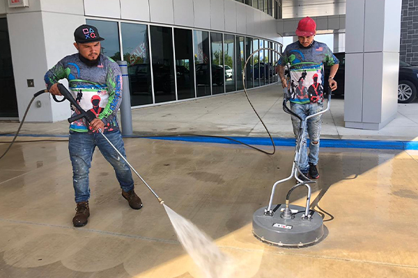 Two Biocleaners USA employees wash and polish a wooden floor.