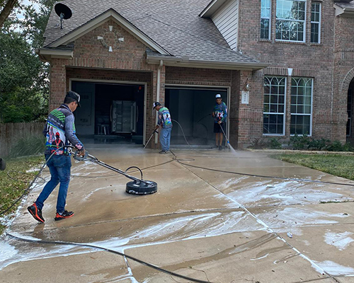 Biocleaners USA team cleaning the patio and garage of a residential house.