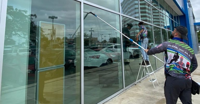 Biocleaners USA staff cleaning windows of a commercial building.