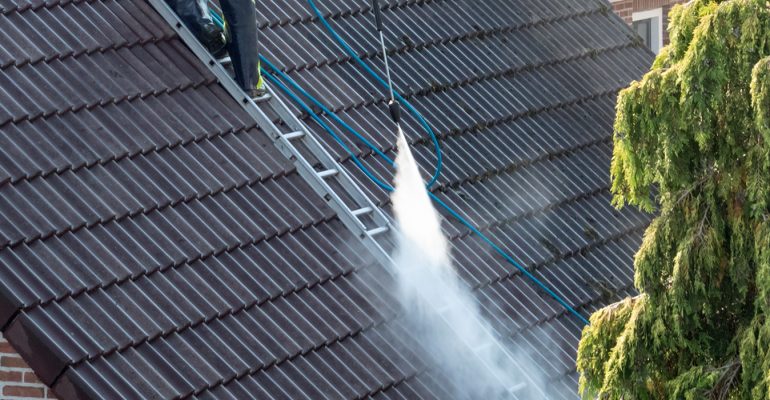 A roof being cleaned using the softwashing technique