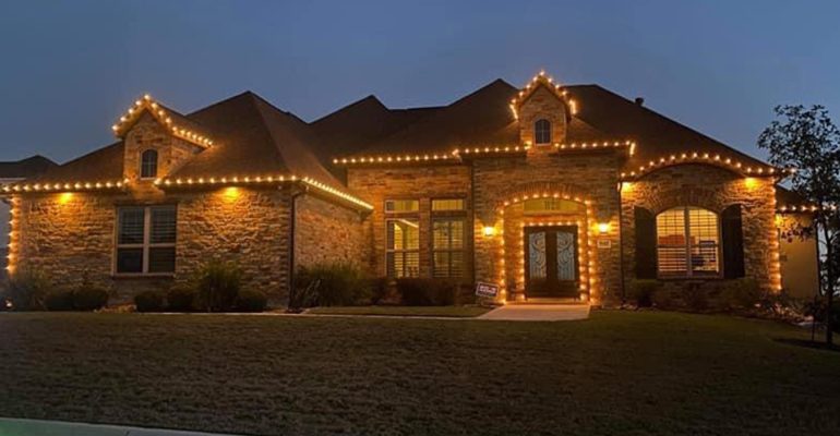 Brick house decorated with Christmas lights.